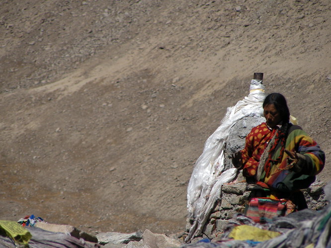Tibetan woman doing prayers on top the Dromala Pass. Mt. Kailash, Tibet.